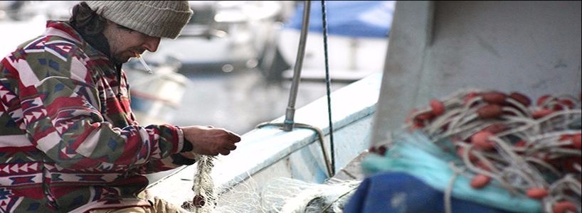 Many of our publications look at the implications of fishing policies for those working in rural fishing communities. Pictured is a fisherman untangling nets.