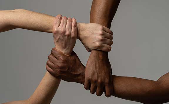 Four arms clutching each other representing the struggle between different ethnicities.