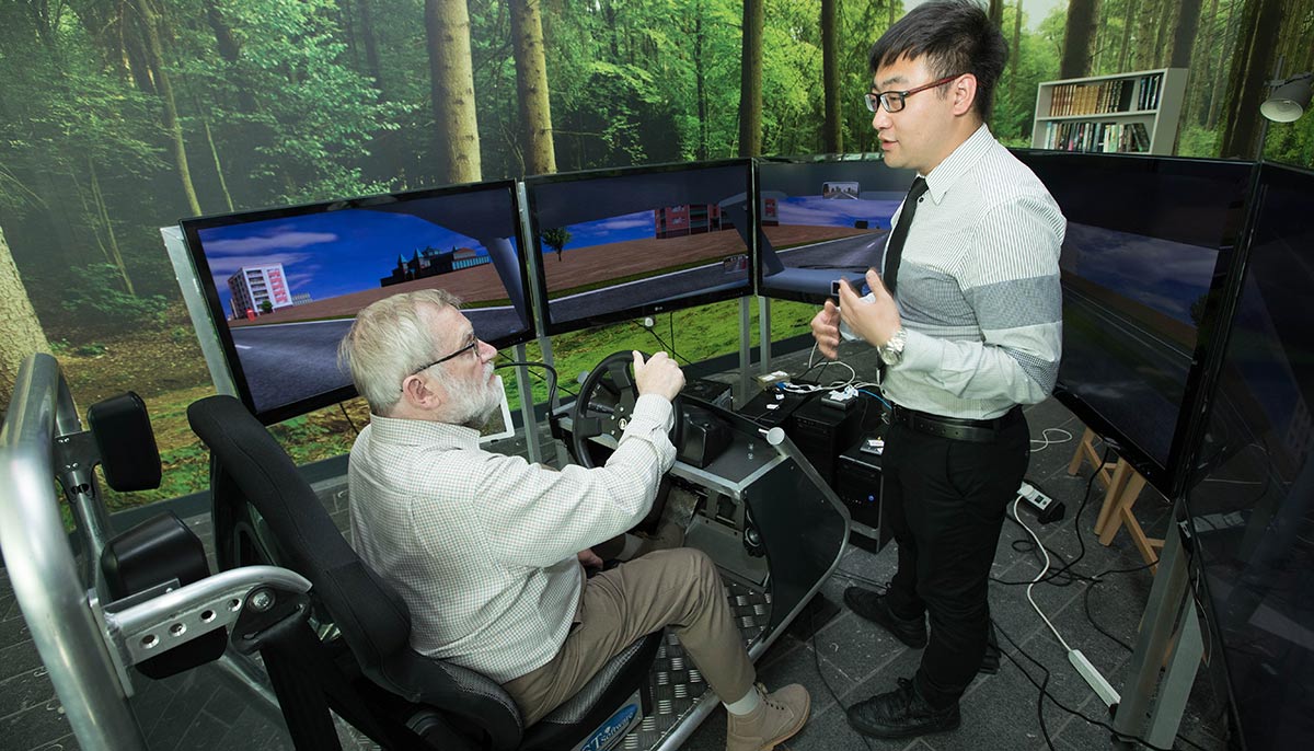 VOICE member Ian Fairclough on the Driving Simulator with lead researcher Dr Shuo Li