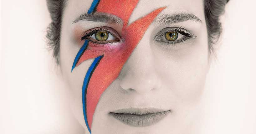 A photograph of a woman wearing Ziggy Stardust make up
