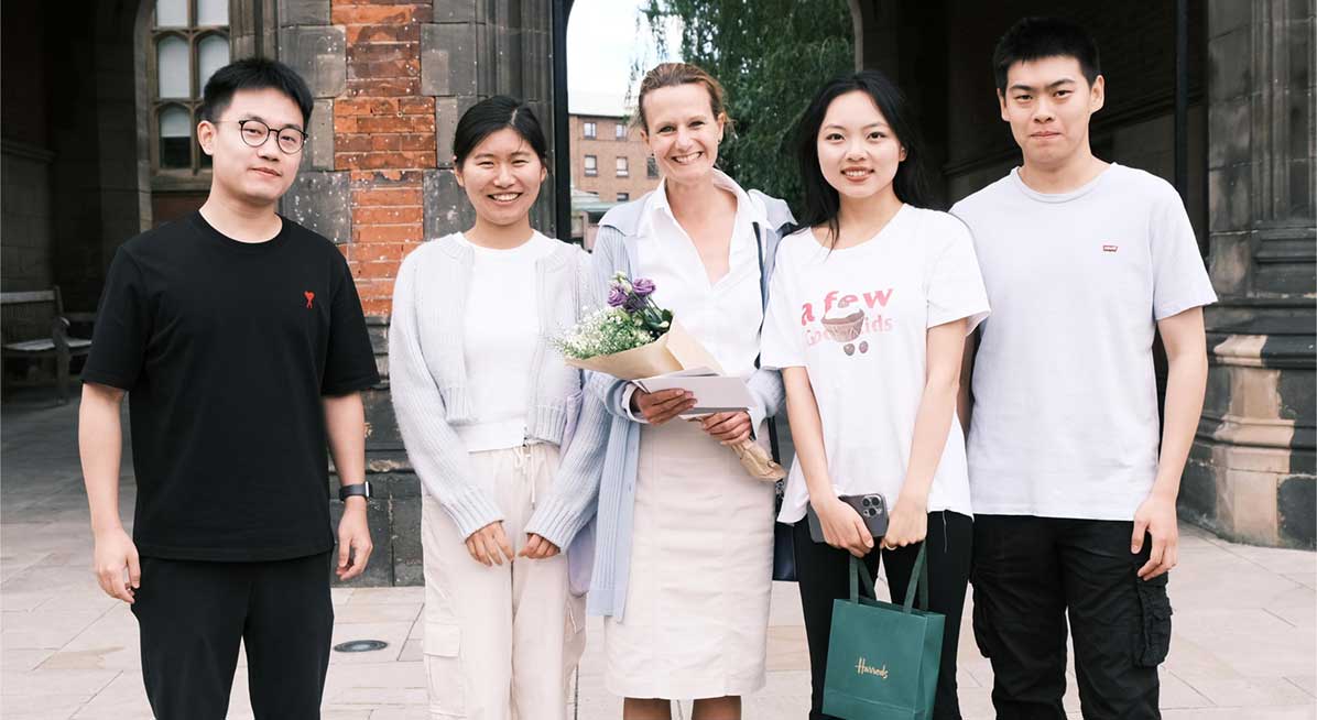 4 students stand in front of the Newcastle University arches