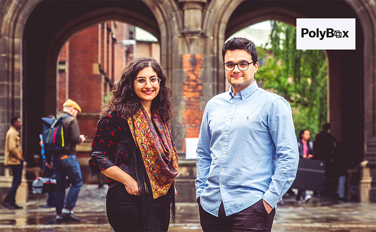 Rojin Yarahmadi and Nick Benopoulos stand in front of a historic archway on the Newcastle University campus Other people are visible in the background. A 