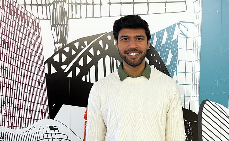 NUBS student Syed Mohammed Irfan standing in front of a mural depicting various North East landmarks	