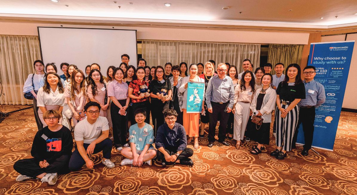 A large group of alumni pose for a group photo at an alumni event in China