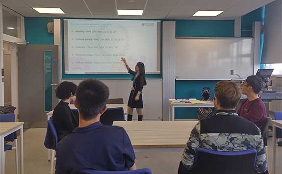 Member of staff delivering a workshop to 4 students