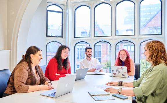 Students discussing work in a seminar room.