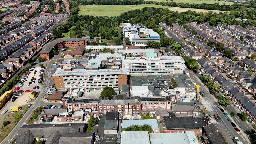 An aerial view looking north across the Health Innovation Neighbourhood. site. The demolition work can be see to have started on the right hand side. But this photo shows the scale of demolition works ahead. The site is huge with many large, old, disused buildings.