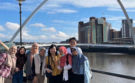IISMA class of 2021 on Newcastle Quayside with Millennium Bridge and BALTIC in the background.